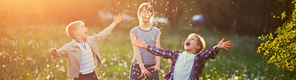 Niños jugando y divirtiéndose al aire libre en un día soleado.