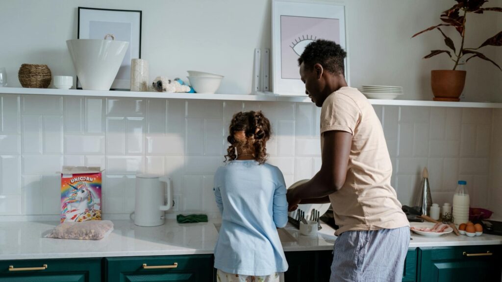 Padre e hija lavando platos.