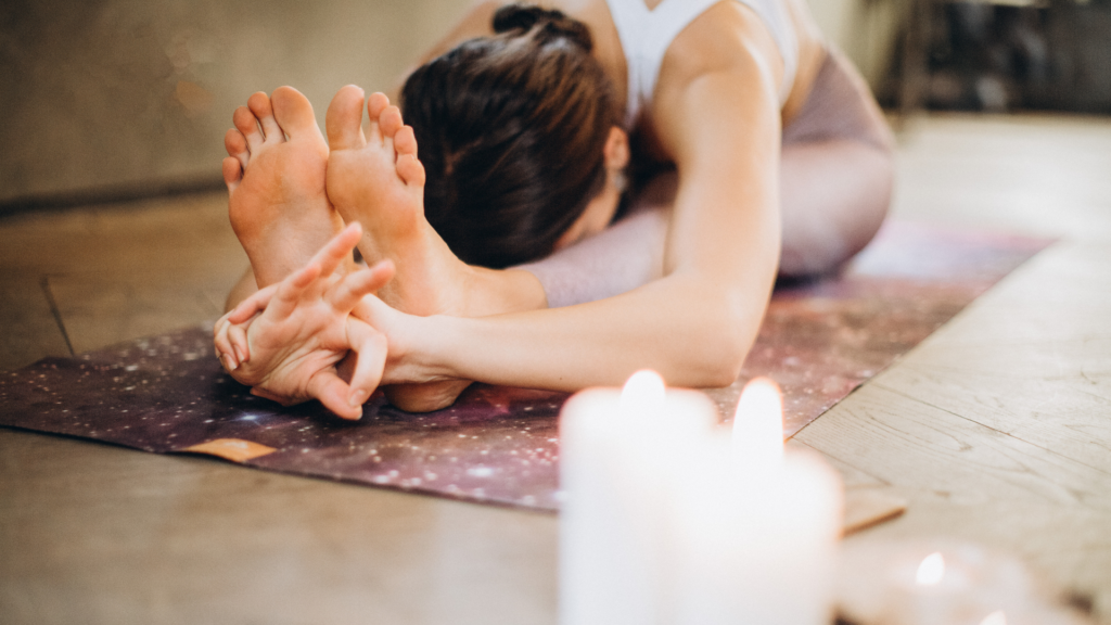 Mujer estirando brazos y piernas en un mat de yoga.