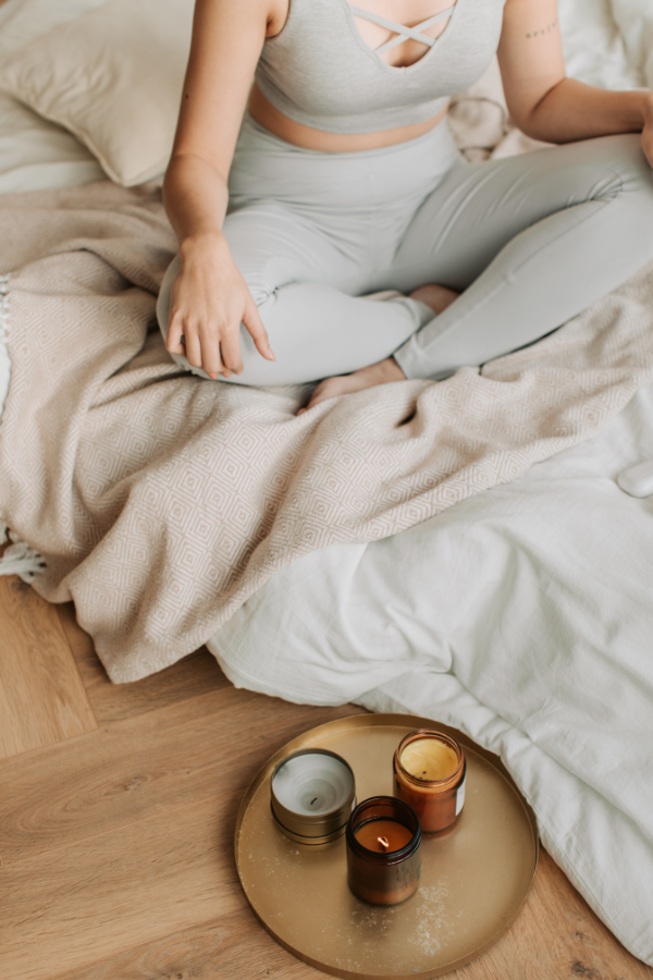 Persona sentada en su cama en posición de meditación.